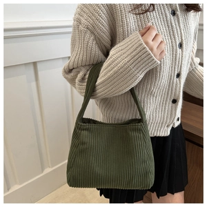 Close-up of dark green corduroy shoulder bag showing vintage texture and handle