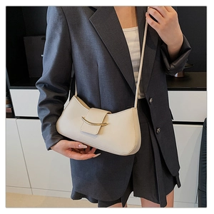 Detail of off-white minimalist baguette bag with gold buckle on a grey blazer outfit