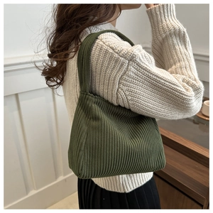 Detail of dark green corduroy shoulder bag with soft textured hobo style fabric