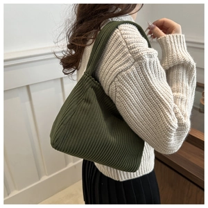 Detail view of the thick vertical knit texture on this dark green corduroy tote bag