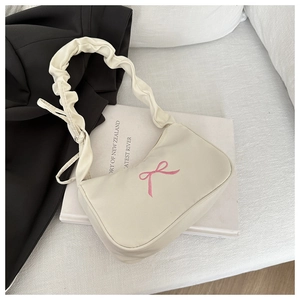 Detail showing the pink bow embroidery and ruched handle on cream shoulder bag