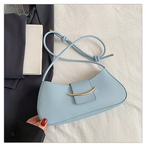Detail of light blue crescent underarm bag with gold metal buckle and leather strap