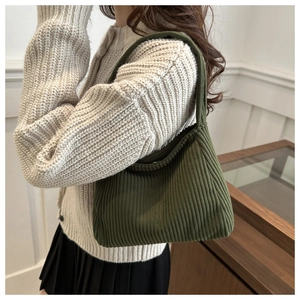 Detail of forest green hobo bag with corduroy texture and vertical knit patterns