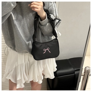 Detail of black nylon shoulder bag with pink bow embroidery and ruched strap design