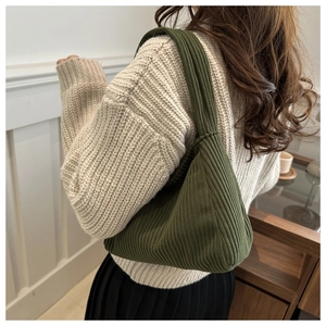Detailed close-up of dark green corduroy shoulder bag showing vertical striped texture