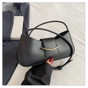 Detail of black matte leather crescent bag with golden metal buckle and knot handle