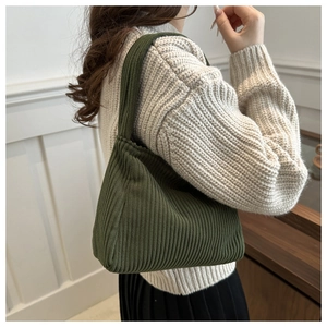 Detail view of dark green ribbed knit shoulder bag texture and stylish underarm design
