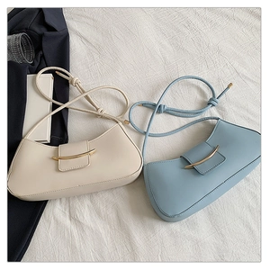 Detail view of large French retro half-moon shoulder bags with golden metal buckle and knot strap