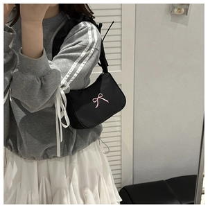 Close-up of black balletcore hobo bag featuring a pink bow embroidery detail