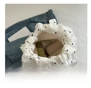 Spacious interior of white pleated tote bag showing storage for umbrella and wallet