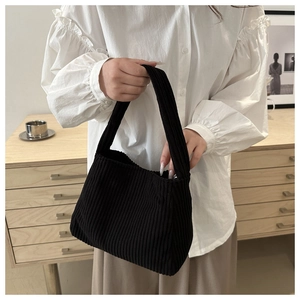 Close-up of black corduroy shoulder bag showing fine vertical stripes and soft texture
