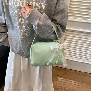 Mint green candy-colored handbag with white lace pearl bow charm in minimalist style