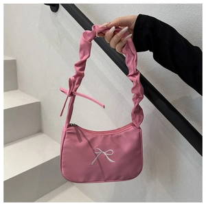 Detailed shot of pink pleated strap shoulder bag with white bow embroidery