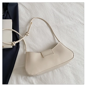 Detail of off-white baguette bag featuring knot strap and matte synthetic leather finish