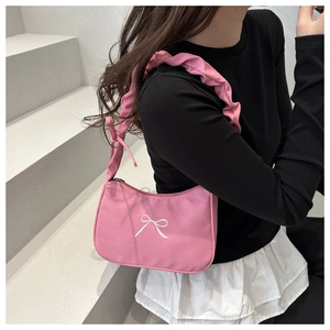 Pink underarm bag detail featuring a white bow embroidery and scrunchie style handle