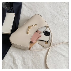 Interior view of the cream shoulder bag showing storage space for phone and makeup