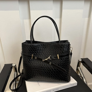 Détail du sac cabas tressé noir avec ferrures dorées et bandoulière réglable