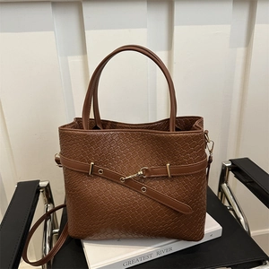 Détail du cabas en cuir tressé marron foncé avec fermoir en métal doré brillant