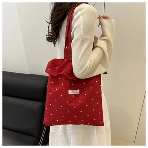 Close-up of red floral tote bag featuring ruffled edges and textured waffle fabric