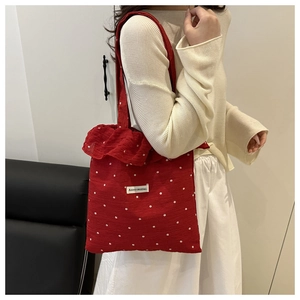 Detailed shot of a red floral tote bag with lace trim and AGOGO ORIGINAL brand tag