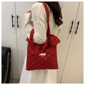 Detail of red floral tote bag with ruffle trim and wide shoulder strap for women