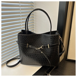 Détail du sac cabas noir à texture serpent avec boucle dorée et finitions soignées