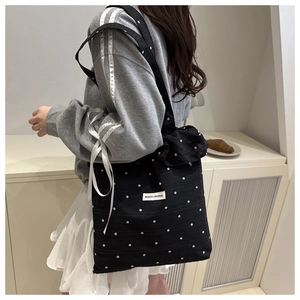 Detail of black floral canvas tote bag with A GOGO ORIGINAL woven label and strap detail