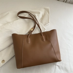 Retro brown leather tote bag with contrast stitching and decorative scarf detail