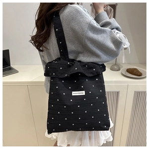 Close-up of black canvas tote bag with star patterns and AGOGO ORIGINAL textile label