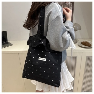 Close-up of black chiffon tote bag featuring white floral patterns and knit texture