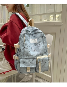 Détail du sac à dos tie-dye marbré avec doubles poches et boucle porté par un mannequin