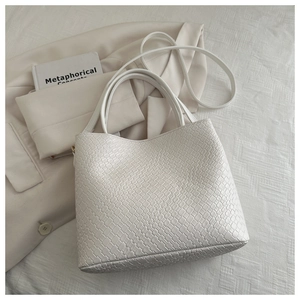 Détail du sac cabas blanc tissé avec poignées et bandoulière réglable amovible
