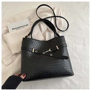 Détail du sac cabas tissé noir avec boucle dorée et bandoulière réglable
