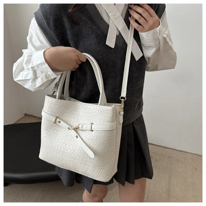 Détail du sac seau blanc motif crocodile avec des boucles métalliques dorées chic