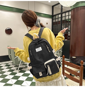 Détail d'un sac à dos tie-dye noir avec plusieurs poches et sangles décoratives