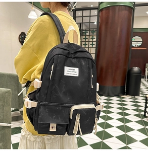 Vue latérale du sac à dos en nylon noir avec sangles réglables et poches multiples
