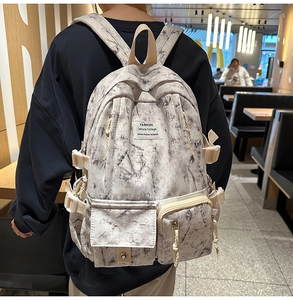 Détail du sac à dos gris à motif marbre avec poches multiples et étiquette mode