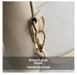 Detail view of the cream leather tote with a gold D-ring and detachable spring hook