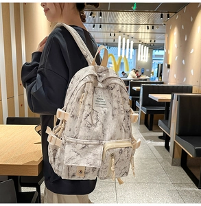 Détail d'un sac à dos tie-dye à motif marbré avec compartiments et sangles réglables