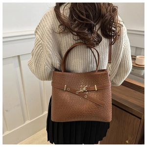 Détail du sac cabas marron en similicuir tressé avec boucle en métal et bandoulière
