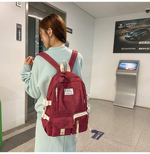 Détail du sac à dos tie-dye bordeaux montrant les boucles et l'étiquette tissée