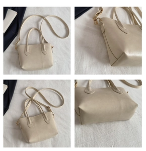 Detail view of cream tote bag with gold hardware and adjustable crossbody strap