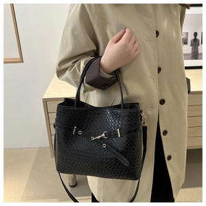 Détail d'un sac cabas noir en similicuir à texture crocodile et finitions dorées