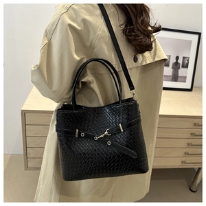 Détail d'un sac cabas noir en similicuir crocodile avec boucle et bandoulière longue