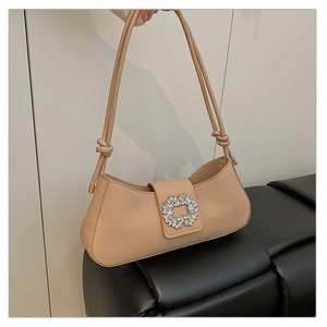 Gros plan du sac baguette beige avec boucle luxueuse en strass et bandoulière en cuir