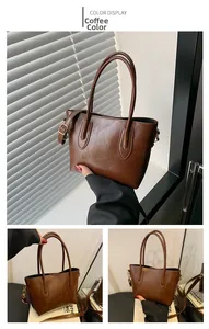 Detail of coffee brown leather tote bag with round handles and adjustable shoulder strap