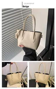 Close-up of beige faux leather tote bag with gold hardware and detachable shoulder strap
