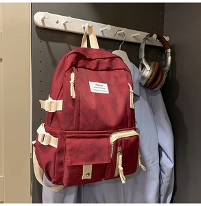 Détail du sac à dos tie-dye rouge marbré avec sangles blanches et étiquette