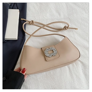 Vue à plat du sac demi-lune avec boucle en strass et détail de bandoulière nouée