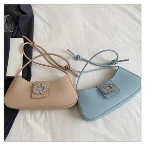 Détail de sacs portés épaule élégants kaki et bleus avec boucles en strass